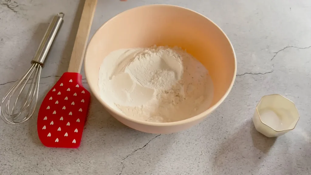 Dry ingredients in a bowl with a spatula and Whisker