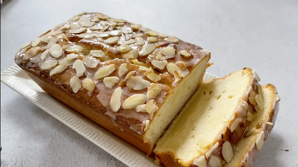 Almond Pound Cake in a dish with chopped almonds on top