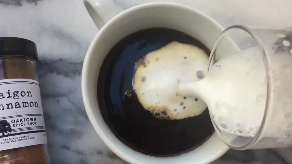 Pouring Frother Milk into Chai Latte Mixture