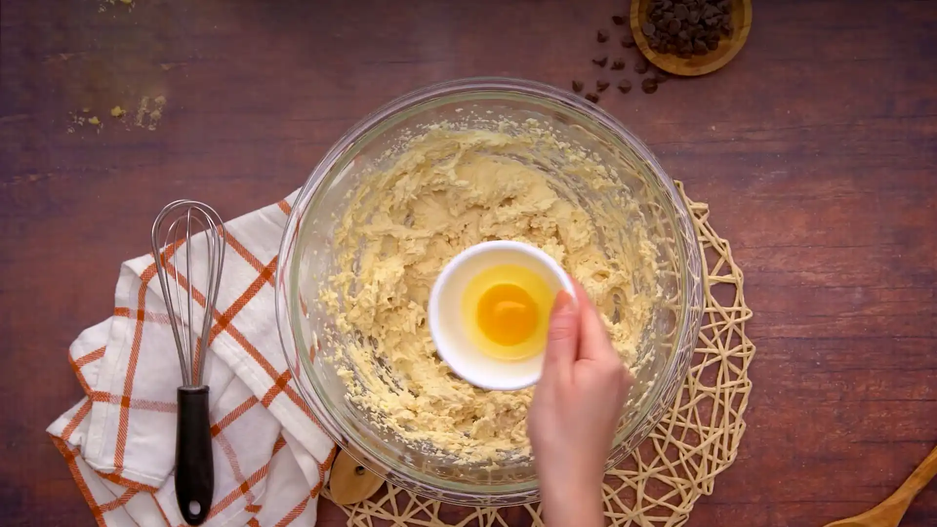 Adding eggs into mixture of Dry ingredients of Toll House Cookie in a Bowl