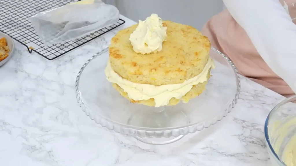 covering the sides and top of pineapple cake with frosting